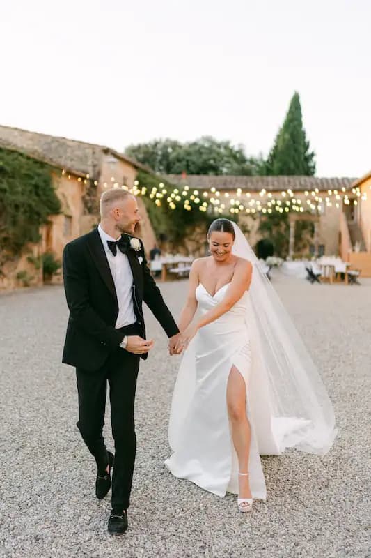 Coppia di sposi mano nella mano nel cortile di una villa toscana al tramonto